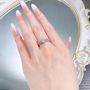 Détail de la bague en argent S925 avec diamant rose ovale et serti halo sur un doigt