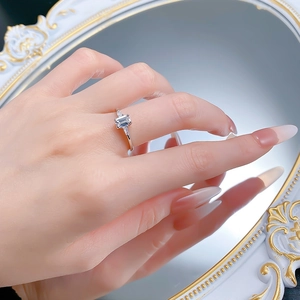 Detail of S925 silver ring with emerald-cut zircon on model hand near mirror