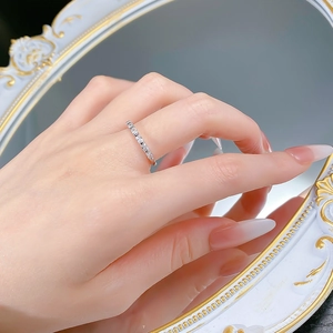 Detail of S925 silver eternity ring with geometric cubic zirconia on a female finger