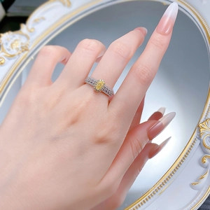 Vue détaillée d'une bague avec gemme jaune ovale et accents de diamants sur le doigt