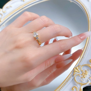 Close-up of gold three-stone ring with rectangle zircon and mirror reflection detail