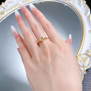 Close-up of gold-plated silver floral ring with white zircon on a model's hand