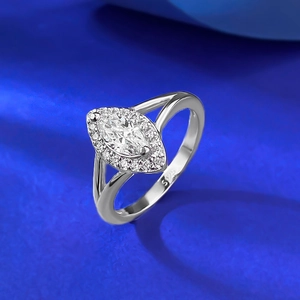 Marquise-cut S925 silver ring with halo design and split-shank band on blue background