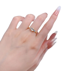 Three-stone gold ring with rectangular and round clear zircons on model's hand