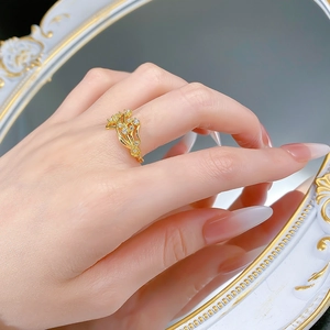 Gros plan d'une bague florale dorée avec zircons brillants sur fond de miroir