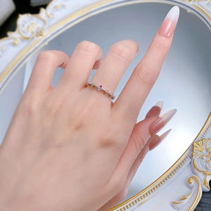 Bague en argent S925 avec pierre rouge et diamants portée devant un miroir