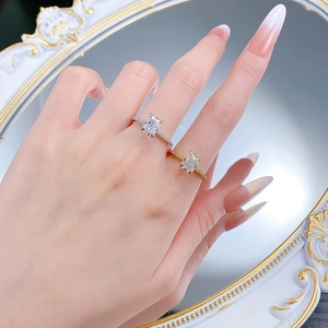 Detail von silbernen und goldenen Ringen mit rechteckigem Strahlenschliff an der Hand