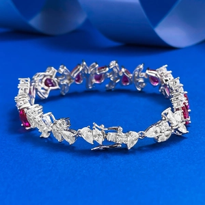 Detailed view of S925 silver bracelet with pear-cut red gems and cluster diamonds