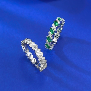 Sparkling S925 sterling silver emerald cut and round eternity rings on blue velvet