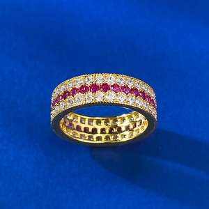 Detail of S925 silver ring with red and white pavé-set stones on textured blue background