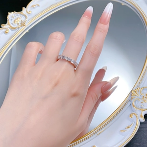 Detailed view of S925 silver wave ring with baguette and round cut diamonds on a mirror