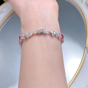 Detailed close-up of S925 silver bracelet with pear-cut red gems and sparkling diamonds