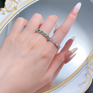 Dettaglio dell'anello in argento S925 con gemme verde smeraldo e diamanti scintillanti