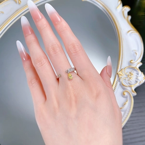 Detail of S925 silver adjustable ring with pear-cut yellow zircon on a model's hand