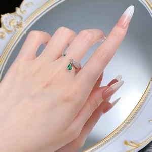 Macro detail of silver adjustable ring with green pear-cut gemstone and cubic zirconia