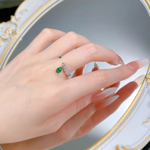 Macro detail of S925 silver adjustable open ring with pear-cut green emerald stone