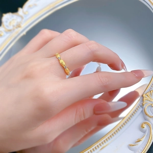 Macro shot of brushed gold S925 silver ring with small white zircons on a finger