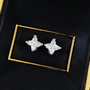 Macro shot of S925 silver star earrings with marquise-cut stones on black velvet