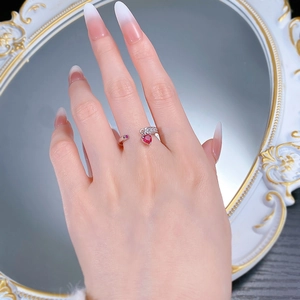 Detail of S925 silver adjustable ring featuring a heart-shaped red gemstone on a hand