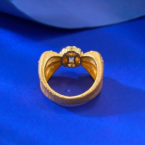 Detailed macro view of gold-plated brushed texture ring with a central round gemstone