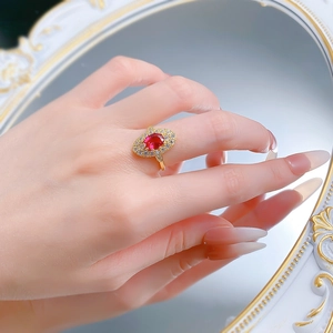 Close-up of S925 silver ring with 6x8mm oval red zircon and white diamond halo