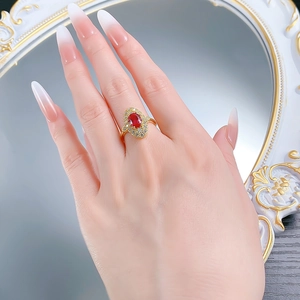 Macro detail of retro gold ring featuring an oval red zircon and diamond accents