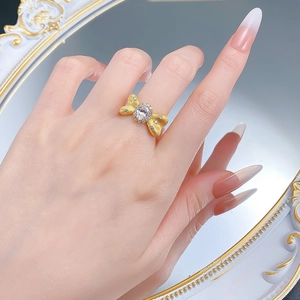 Detailed close-up of S925 sterling silver bow ring with brushed gold finish and oval gem