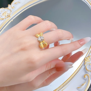 Close-up of S925 sterling silver bow ring with brushed gold finish and oval gemstone