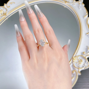 Dettaglio dell'anello con pietra ovale e montatura dorata indossato sulla mano