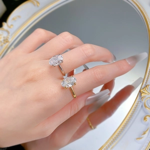 Dettaglio di anelli in argento S925 e placcati oro con gemma ovale su specchio
