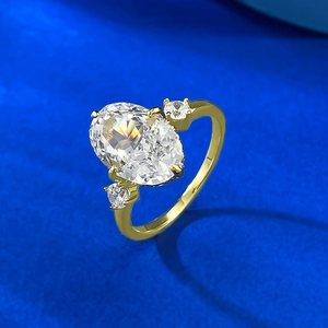 Detail of gold oval ice-cut carbon diamond ring featuring side stones and claw setting