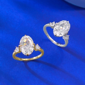 Silver and gold plated oval ice flower cut rings with three-stone setting on blue fabric