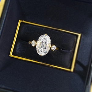 Top view of gold-plated oval ice flower cut carbon diamond ring in blue velvet jewelry box
