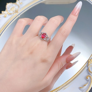 Close-up of S925 silver ring with red oval gemstone and diamonds on a hand