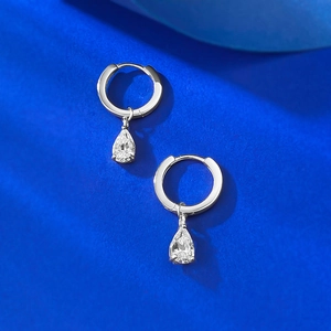 Vue macro des boucles d'oreilles créoles en argent S925 avec pierres poires en zircon