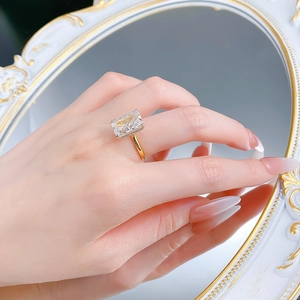 Detail of s925 silver gold ring featuring a large emerald cut sparkling gemstone