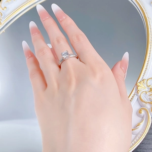 Close-up of a silver S925 ring with a classic four-prong round moissanite on a hand