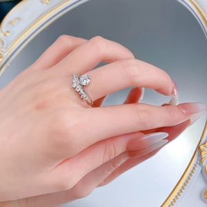 Macro shot of silver crown ring with round center stone reflecting in a vintage mirror