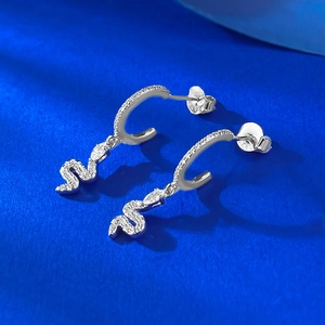 Elegant 925 sterling silver snake earrings with pavé white zircons on blue textured background