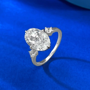 Macro detail of oval ice-flower cut gemstone and round side stones on a silver ring