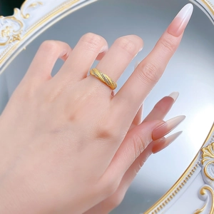 Close-up of gold brushed woven ring with micro-pave diamonds on female finger