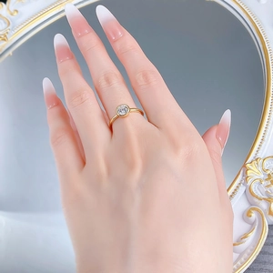 Détail d'une bague en argent S925 doré avec zircon de 6mm portée au doigt