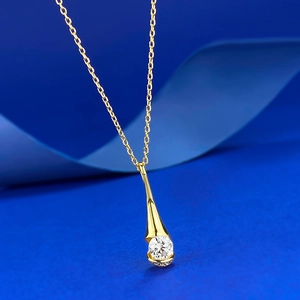 Detail showing a gold teardrop pendant with a round brilliant-cut white zircon stone