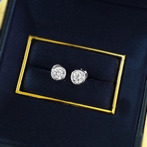 Macro shot of S925 silver round solitaire stud earrings in a blue velvet box