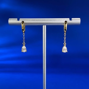 Detailed close-up of pear-shaped drop earrings with gold plating and clear gemstones