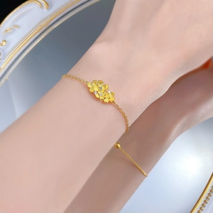 Macro view of gold flower bracelet with brushed petals and sparkling zircon centers