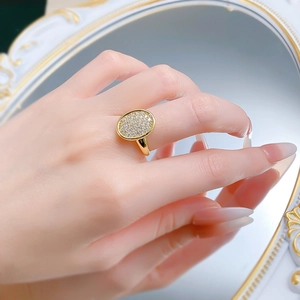 Detail shot of vintage oval pavé ring with shimmering crystals on a golden band