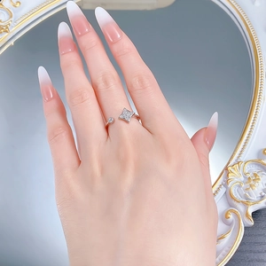 Gros plan d'une bague trèfle en argent S925 avec cristaux scintillants sur une main