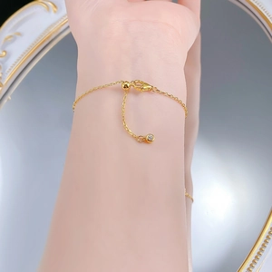 Macro detail of gold S925 silver flower bracelet with lobster clasp and cubic zirconia charm