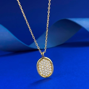 Elegante goldene Halskette mit ovalem Kristallanhänger auf dunkelblauem Hintergrund